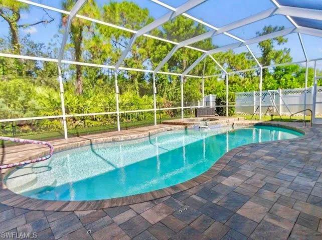 Swimming pool with a lanai, a jacuzzi, a sunroom, and a patio