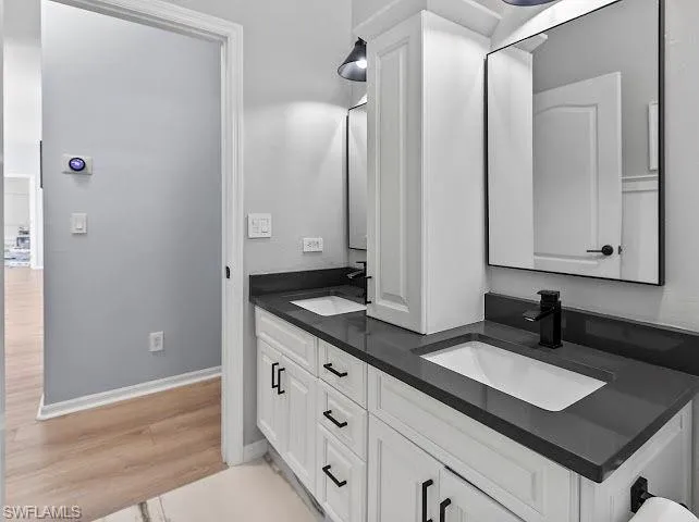 Bathroom with double vanity and light wood-style floors