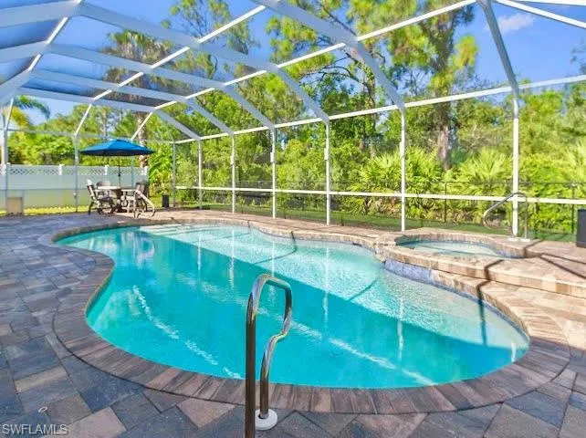 View of swimming pool featuring a lanai, a patio, and a pool with connected hot tub