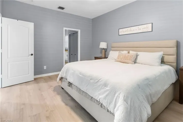 Bedroom with light wood-style flooring and ensuite bath