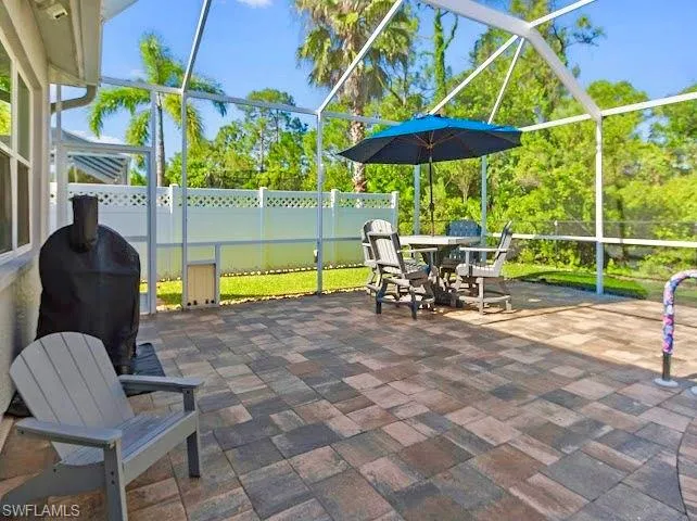 View of patio / terrace featuring a sunroom, a lanai, and a grill