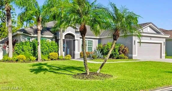 Ranch-style house with stucco siding, an attached garage, a front yard, and concrete driveway