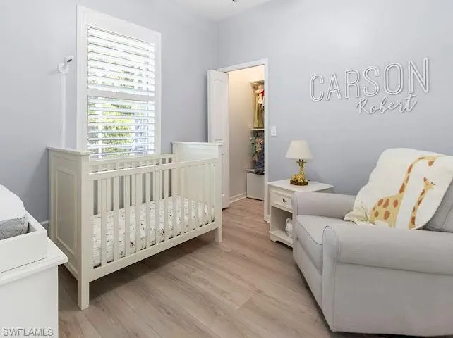 Bedroom with a walk in closet and light wood-type flooring