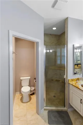 Full bath featuring vanity, a shower stall, light tile patterned floors, and recessed lighting