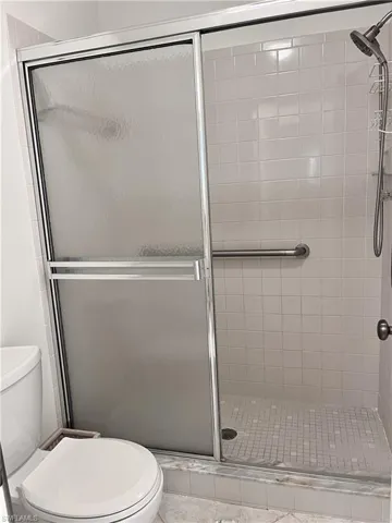 Bathroom featuring an enclosed shower and toilet
