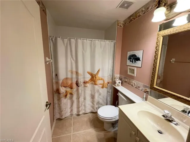 Bathroom with vanity, tile patterned floors, and toilet