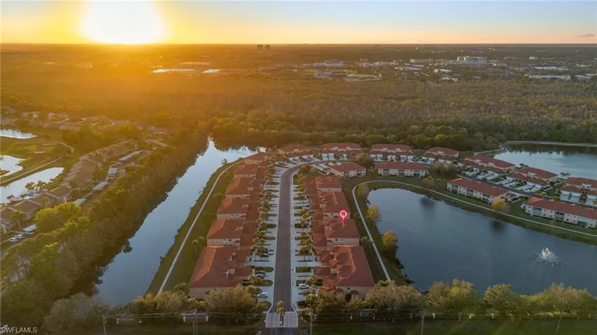 Aerial view at dusk featuring a water view