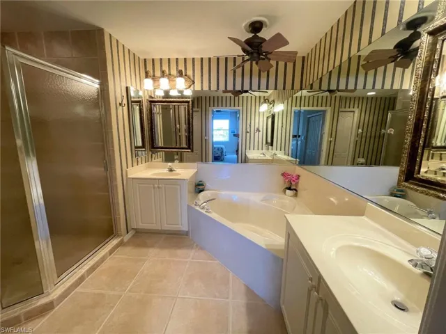 Bathroom with vanity, tile patterned floors, plus walk in shower, and ceiling fan