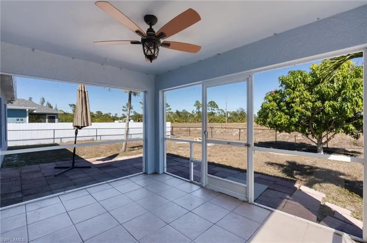 Unfurnished sunroom with ceiling fan and plenty of natural light