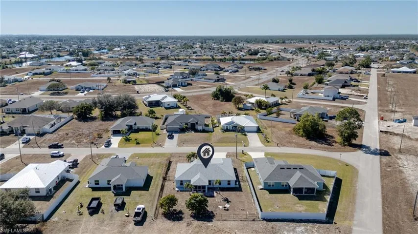 Aerial view of property and surrounding area with nearby suburban area