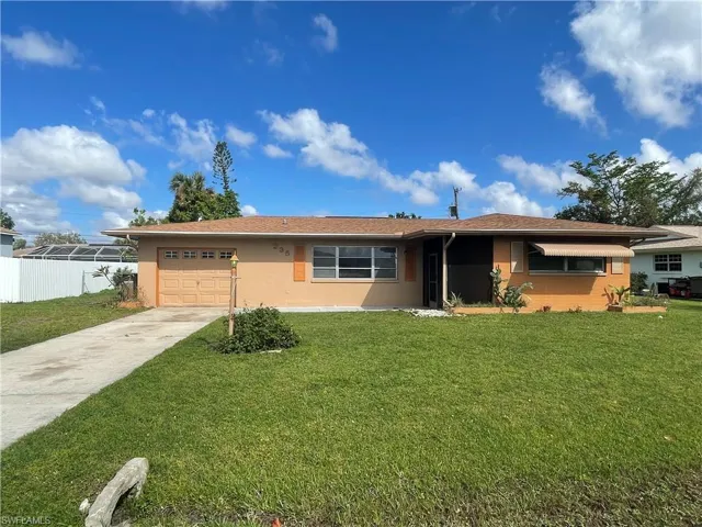 Single story home with a front yard and a garage