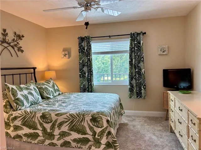 Bedroom with ceiling fan and light carpet