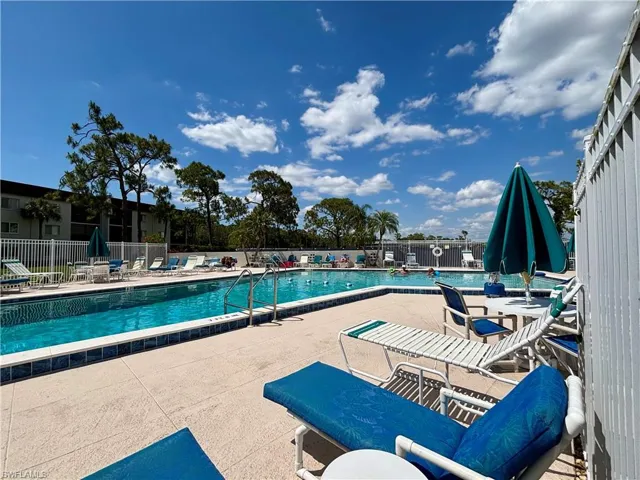 Pool with a patio area and fence