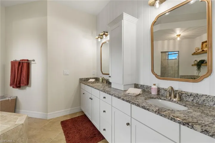 Bathroom featuring double vanity and light tile patterned floors
