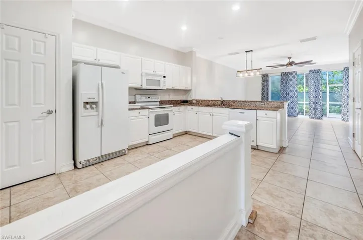 Kitchen with pendant lighting, white cabinets, white appliances, and crown molding