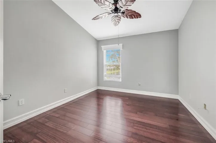 Second bedroom featuring ceiling fan and dark hardwood / wood-style floors