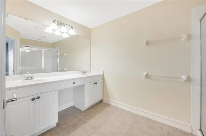 Bathroom with vanity, tile patterned floors, and a shower with door