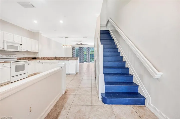 Staircase featuring ceiling fan, crown molding, sink, and tile patterned floors