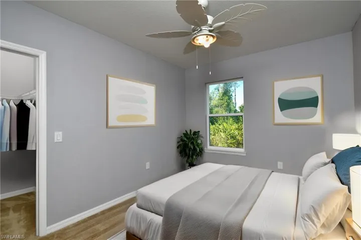 Carpeted bedroom with ceiling fan, a closet, and a walk in closet