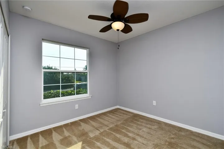 Empty room with carpet and ceiling fan