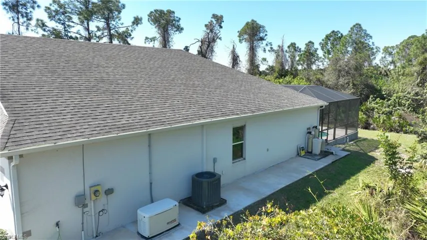 View of side of home with a lawn and central air condition unit