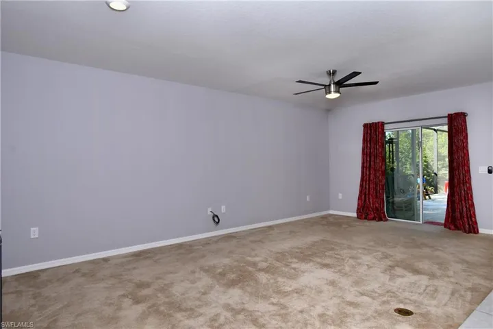 Unfurnished room featuring ceiling fan and light colored carpet