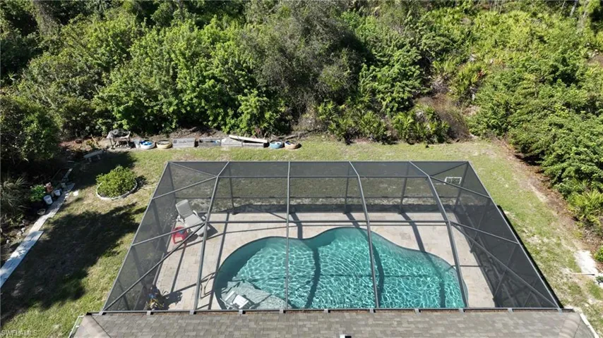 View of swimming pool featuring a lanai