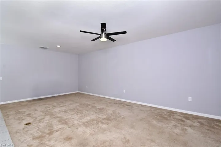 Carpeted spare room with ceiling fan