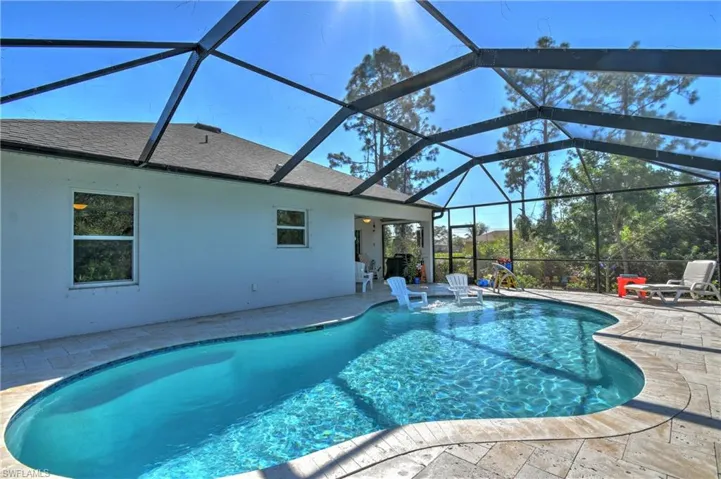 View of swimming pool with a lanai, pool water feature, and a patio area