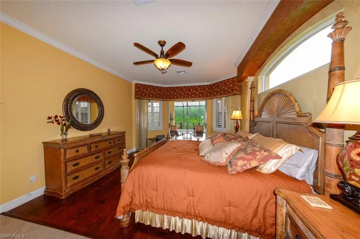 Bedroom featuring crown molding, dark hardwood / wood-style flooring, and ceiling fan