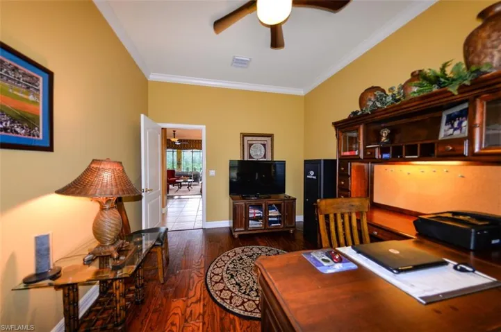 Tiled office with crown molding and ceiling fan