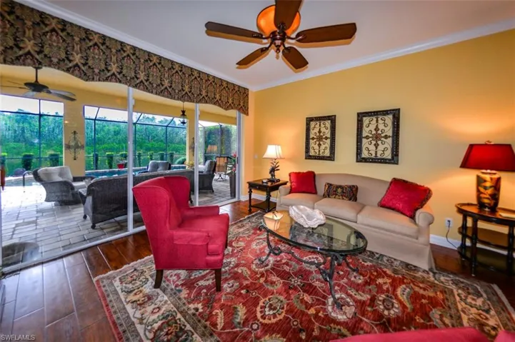 Living room featuring ceiling fan, hardwood / wood-style flooring, and ornamental molding