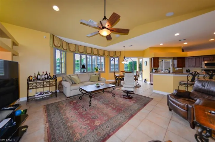 Living room featuring light tile patterned flooring, plenty of natural light, and ceiling fan
