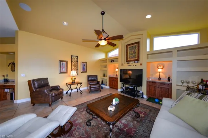 Tiled living room with a high ceiling and ceiling fan
