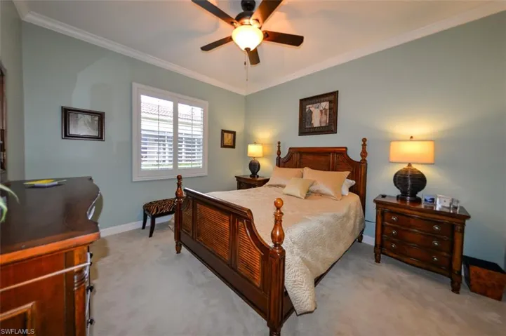 Carpeted bedroom featuring ornamental molding and ceiling fan