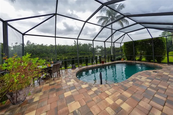 View of swimming pool with a patio and glass enclosure