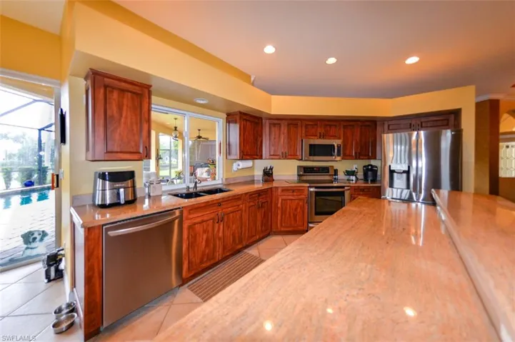 Kitchen with light tile patterned flooring, appliances with stainless steel finishes, and sink