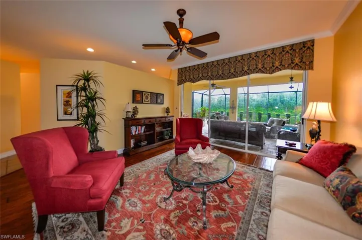 Living room featuring ceiling fan, hardwood / wood-style flooring, and ornamental molding