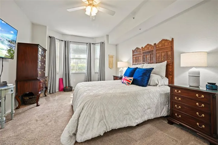 Bedroom with light colored carpet and ceiling fan