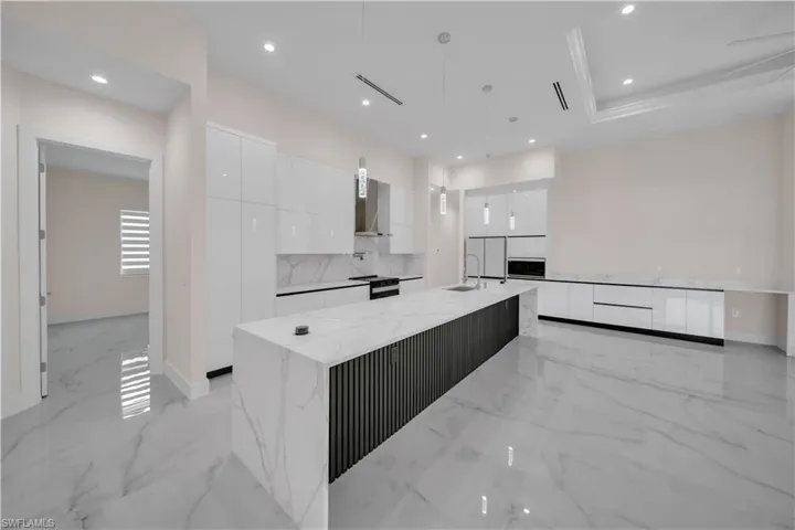 Kitchen featuring white cabinetry, marble finish floor, modern cabinets, and a sink