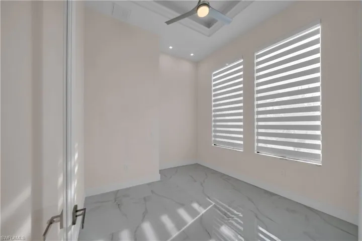 Spare room featuring marble finish floor, baseboards, visible vents, and recessed lighting
