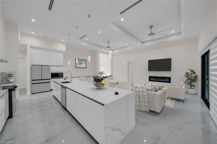Kitchen featuring a sink, white cabinetry, modern cabinets, ceiling fan, and a raised ceiling