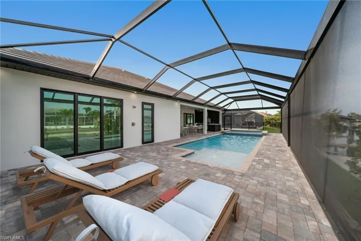 Outdoor pool with glass enclosure and a patio area