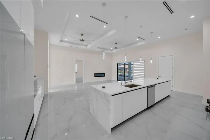Kitchen featuring marble finish floor, modern cabinets, a ceiling fan, white cabinetry, and a sink