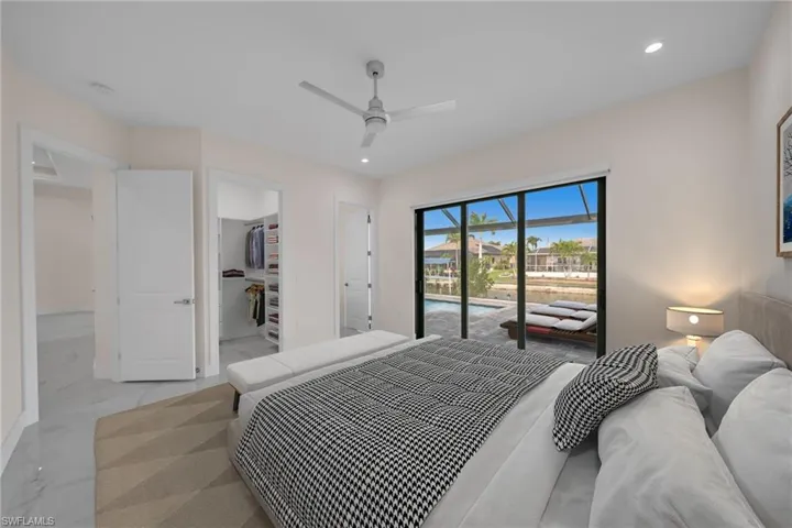 Bedroom with a ceiling fan, a walk in closet, marble finish floor, access to exterior, and recessed lighting