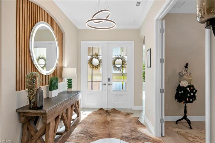 Welcoming foyer with double entry doors and wood detailed niche.