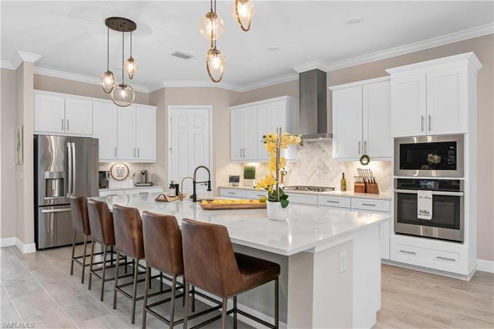 Kitchen offers beautiful designer pendant lighting, upgraded refrigerator/freezer, natural gas stove, spacious pantry and plenty of cabinet space.