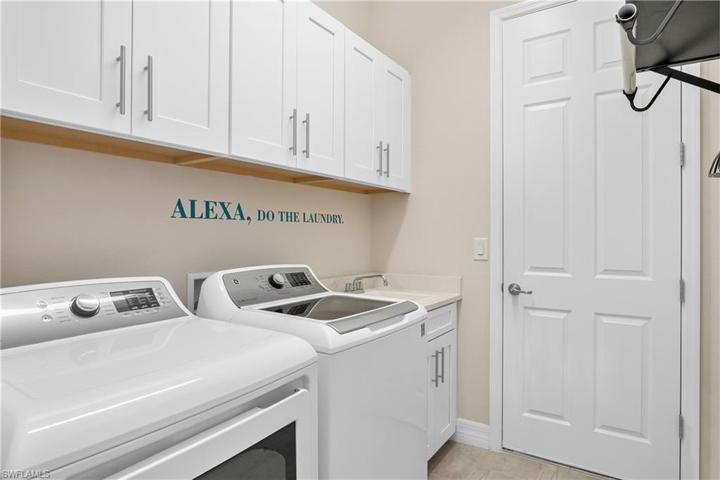 Laundry room includes additional storage space and utility sink.