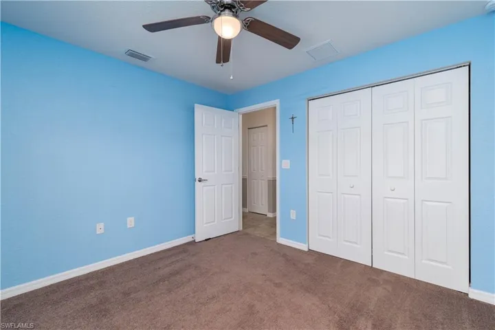 Unfurnished bedroom featuring carpet flooring, a closet, and ceiling fan