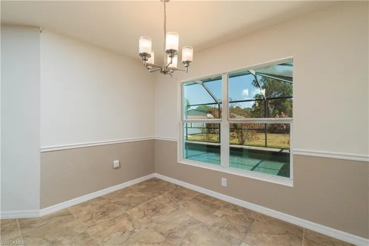 Unfurnished dining area with a chandelier and a textured wall